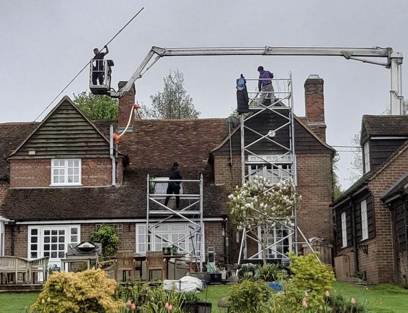 The Moss Cleaners using cherry picker and scaffolding to clean roof safely and professionally in Basingstoke, Hampshire